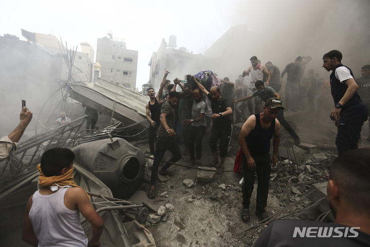 9일(현지시각) 가자지구 팔레스타인 주민들이 이스라엘의 공격으로 파괴된 건물 잔해에서 희생자 시신을 수습하고 있다. (AP/뉴시스) 2023.10.10.