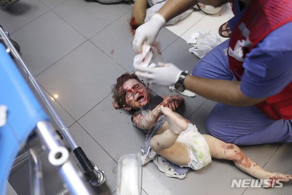 이스라엘의 가자지구 폭격으로 부상을 당한 어린이가 병원 바닥에서 응급 처방을 받고 있다.. (출처: 뉴시스, AP)