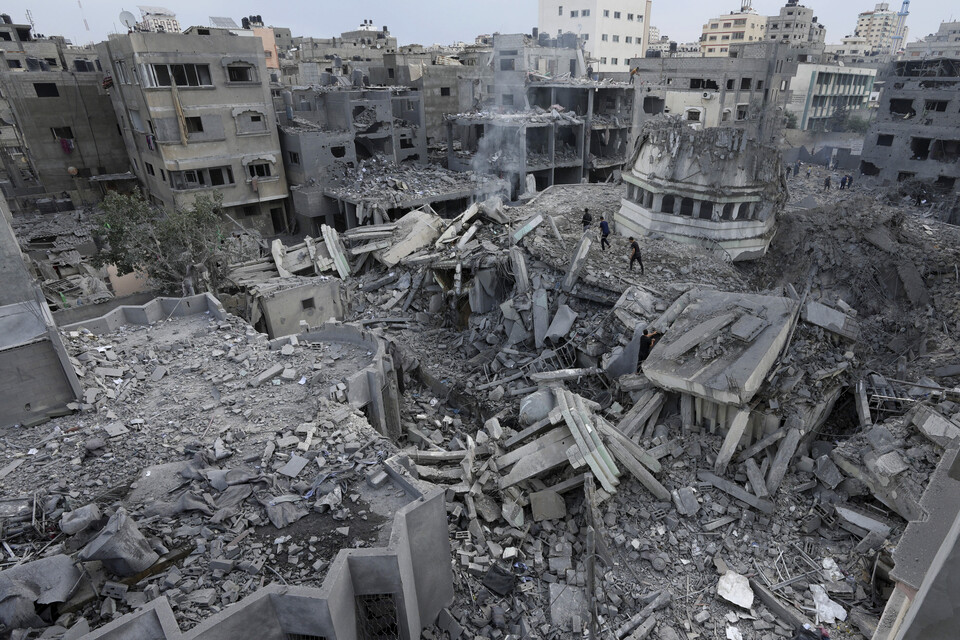 12일(현지시간) 가자지구 남부 라파시에서 팔레스타인인들이 이스라엘의 공습으로 파괴된 건물 잔해를 수색하고 있다 (AFP/연합뉴스) 2023.10.16.