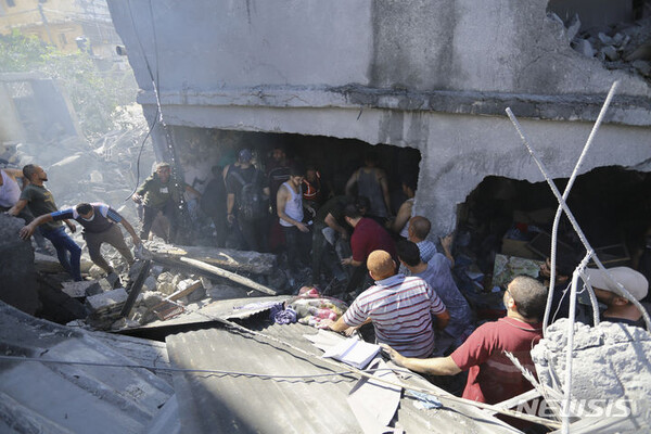 건물 잔해 속 생존자 찾는 팔레스타인 주민들[가자지구=AP/뉴시스] 18일(현지시각) 가자지구 가자시티의 팔레스타인 주민들이 이스라엘의 공습으로 파괴된 잔해 속 생존자를 찾고 있다.