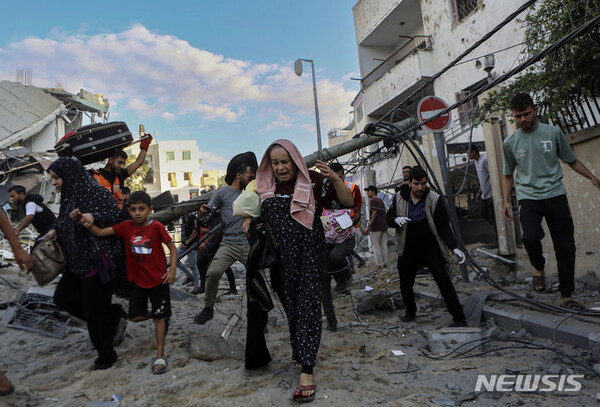 [가자지구=AP/뉴시스] 17일(현지시각) 가자지구 중심가 가자시티에 이스라엘의 공습이 시작되자 팔레스타인 주민들이 집에서 뛰쳐나오고 있다.