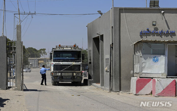 가자 지구 주민들에게 전달될 구호품이 이집트 국경을 통해 반입되기 시작했다고 AP통신이 21일(현지시간) 보도했다. 사진은 2021년 6월21일 가자 지구 남부 케렘 샬롬 통로에서 하마스 보안 요원이 트럭을 확인하는 모습. (출처: 라파=AP/뉴시스)