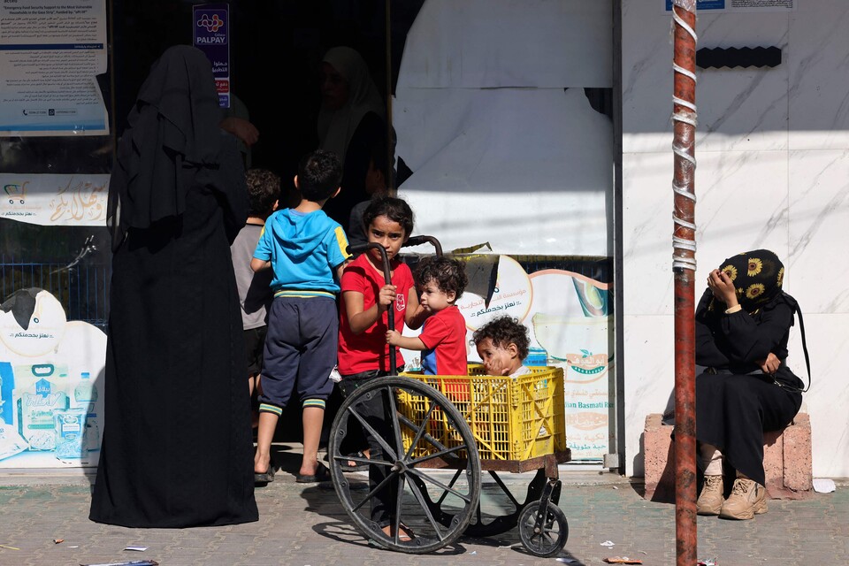 21일(현지시간) 팔레스타인 주민들이 국경지대 라파에 있는 슈퍼마켓 앞에서 식량 배급을 기다리고 있다. (AFP/연합뉴스) 2023.10.23.