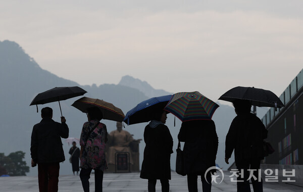 [천지일보=남승우 기자] 전국이 대체로 흐리고 비가 오겠다고 예보된 14일 서울 종로구 광화문광장에서 시민들이 우산을 쓴 채 이동하고 있다. ⓒ천지일보 2023.10.14.