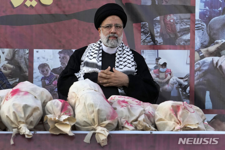 에브라힘 라이시 이란 대통령이 지난 18일(현지시각) 테헤란의 혁명광장에서 열린 반이스라엘 집회에 참석해 희생된 팔레스타인 어린이 상징물들을 앞에 두고 가슴에 양손을 얹고 있다. 라이시 대통령은 “전 세계 사람들은 미국을 이스라엘의 공범으로 생각한다”라고 말했다.(AP/뉴시스) 2023.10.24.