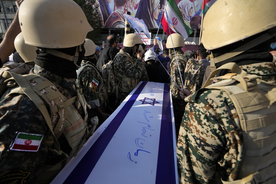 18일(현지시각) 이란 바시즈 민병대원들이 테헤란의 혁명광장에서 열린 반이스라엘 집회 중 이스라엘의 죽음을 상징하는 관을 옮기고 있다. (AP/뉴시스) 2023.10.24.
