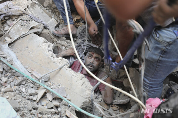 [AP/뉴시스] 24일 이스라엘 보복 공습을 당한 가자 지구의 누세이라트 난민 캠프에서 잔해 더미에 깔려있던 한 사람이 구조되고 있다.
