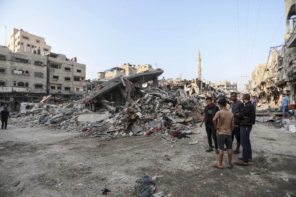 28일(현지시간) 가자지구 팔레스타인 주민들이 이스라엘의 공습으로 인해 파괴된 건물들을 바라보고 있다. (AP/연합뉴스) 2023.10.30.