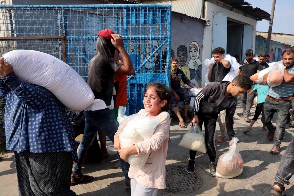 28일(현지시간) 팔레스타인 주민들이 UN이 운영하는 원조지원센터에서 식량을 배급받고 있다. (AFP/연합뉴스) 2023.10.30.