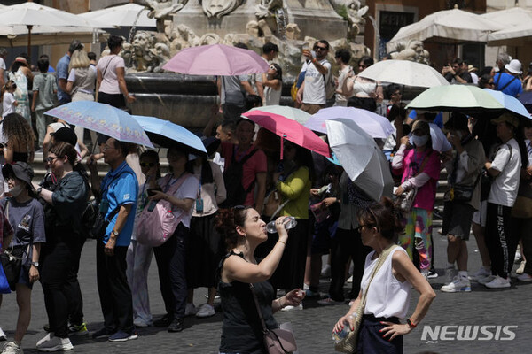 [로마=AP/뉴시스] 이탈리아 일부 지역에서 7월 12일 기온이 45도에 이르는 폭염이 예보됐다. 이탈리아 기상학회는 단테 신곡에 등장하는 머리 셋 달린 지옥의 문지기 '케르베로스' 폭염이라고 명명했다. 사진은 지난 7월 8일 이탈리아 로마에서 태양을 피하기 위해 우산 아래에 숨은 관광객들의 모습. 2023.11.02.