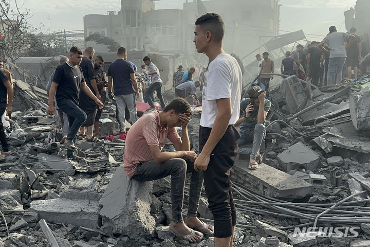 지난달 31일(현지시각) 가자지구 자발리야 난민촌에서 이스라엘 폭격 생존자들이 무너진 건물 잔해에 넋을 잃고 앉아 있다. (AP/뉴시스) 2023.11.01.