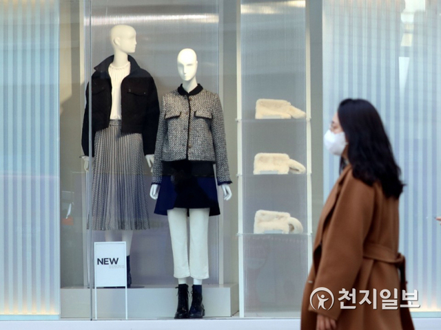 [천지일보=남승우 기자] 25일 오후 쇼윈도에 봄옷이 진열된 서울 중구 명동거리의 한 의류매장 앞으로 코트를 입은 시민이 지나가고 있다. ⓒ천지일보 2021.1.25