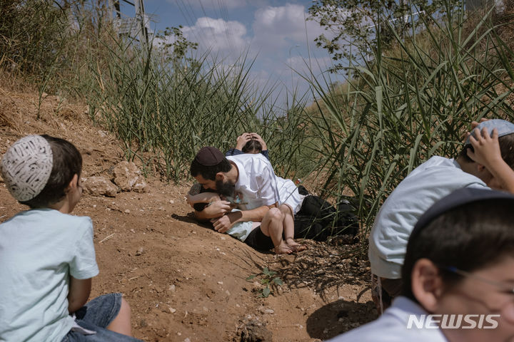 지난 10월 13일 이스라엘 르호봇에서 가자지구로부터 발사된 로켓에 대한 경고 사이렌이 울리자 주민들이 몸을 숨기고 있다. (출처: 뉴시스)