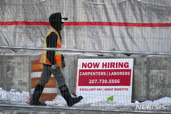 [포틀랜드=AP/뉴시스]지난 1월25일 미국 메인주 포틀랜드의 한 건설 현장에서 노동자가 고용 표지판 앞을 지나는 모습. 2023.12.09