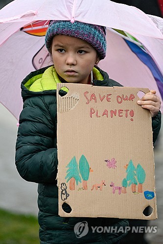 9일 영국 스코틀랜드 에든버러에서 열린 기후 정의를 위한 세계 행동의 날 집회에서 한 소녀가 플래카드를 들고 있다. (출처: 연합뉴스)