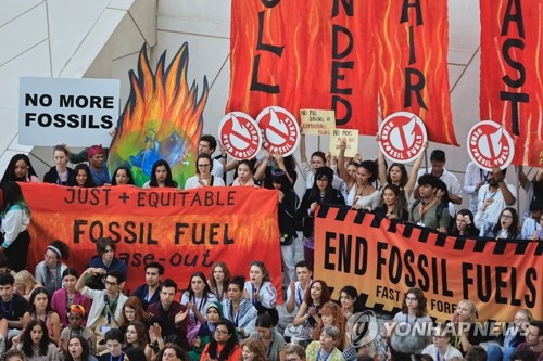 (로이터통신=연합뉴스) 기후 활동가들이 지난 12일(현지시간) 제28차 유엔기후변화협약 당사국총회(COP28)가 열린 아랍에미리트(UAE) 두바이에서 화석연료 사용에 반대하는 시위를 벌이고 있다. 올해 의장국인 UAE는 화석연료의 ‘단계적 퇴출’ 대신 ‘화석연료로부터의 전환’을 내용으로 하는 합의문 초안을 13일 공유했다.