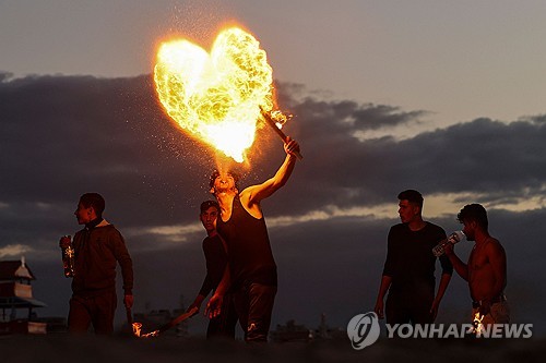팔레스타인 청년들이 지난 1월 13일 가자지구 가자시티 해변에서 불을 이용한 쇼를 보이고 있다. (출처: 연합뉴스)
