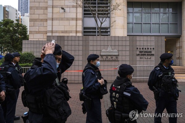 (출처: AP, 연합뉴스) 지난 19일 홍콩 반중매체 빈과일보의 사주 지미 라이의 국가보안법 재판이 진행된 홍콩 서구룡 법원 앞을 경찰이 지키고 있는 모습. 