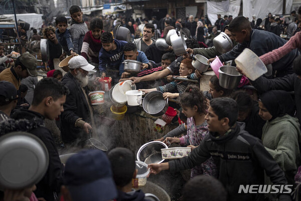 [라파=AP/뉴시스] 21일(현지시각) 가자지구 라파의 배식소에 무료 음식을 받으려는 팔레스타인인들이 몰려들고 있다. 2023.12.22.