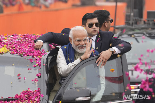 나렌드라 모디 인도 총리가 지난달 30일 인도 아요디아에서 열린 신공항 및 기차역 개장식 전 로드쇼에서 군중을 향해 손을 흔들고 있다. (출처: 뉴시스)