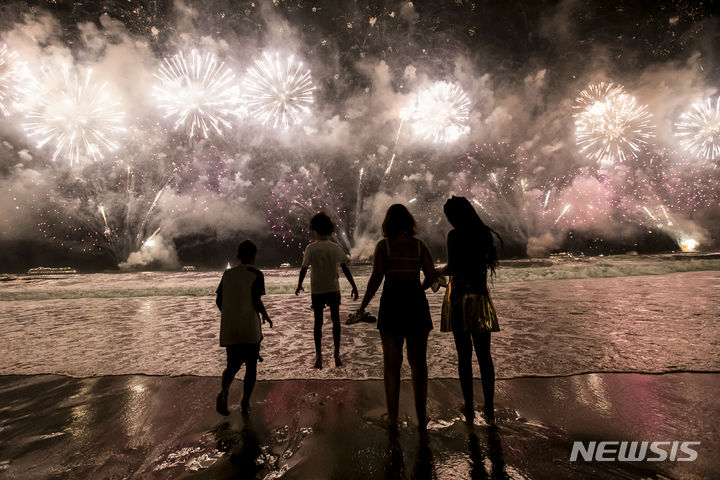 1일 아침 브라질 리우데자네이루의 코파카바나 해변에서 불꽃놀이가 펼쳐지는 가운데 시민들이 새해의 시작을 축하하고 있다.