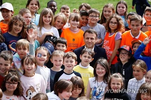 에마뉘엘 마크롱 프랑스 대통령이 지난해 4월 어린이들과 함께 있는 모습. (출처: 연합뉴스)
