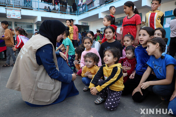작년 11월 8일(현지시간) 가자지구 남부 도시 칸 유니스에 있는 유엔 팔레스타인 난민구호기구(UNRWA) 산하 학교에서 한 자원봉사자가 심리적 자극 및 구호 활동을 하는 동안 어린이들과 교류하고 있다. (출처: 뉴시스)