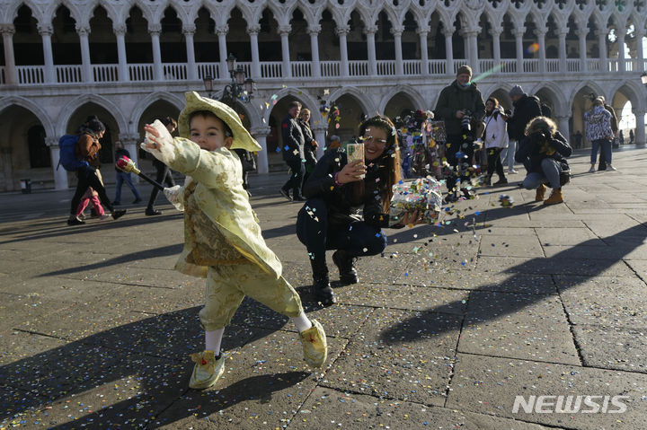 이탈리아 베네치아 카니발이 28일(현지시간) 개막한 가운데 산마르코 광장에서 의상을 입은 어린이가 색종이를 뿌리고 있다. (출처: 뉴시스)