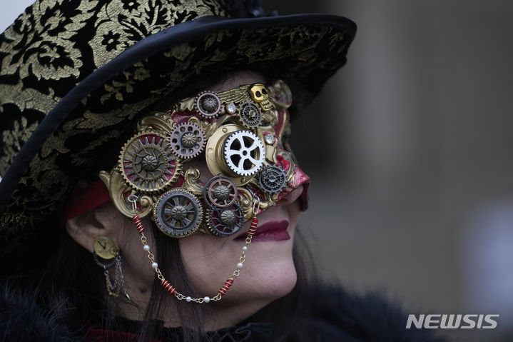 이탈리아 베네치아 카니발이 28일(현지시간) 개막한 가운데 산마르코 광장에서 축제에 참가한 한 여성이 눈에 띄는 가면을 쓰고 있다. (출처: 뉴시스)