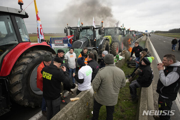 [조시니=AP/뉴시스] 30일(현지시각) 프랑스 파리 동쪽 조시니에서 고속도로를 막고 시위를 벌이던 농민들이 간단하게 점심을 먹고 있다. 정부의 농업 정책에 반대하며 2주째 시위를 이어가는 프랑스 농민들이 파리 외곽을 트랙터로 포위하고 시위 강도를 높이고 있다. 프랑스 정부는 문제가 됐던 농업용 경유 과세 조치를 철회하는 등의 조치에 나섰지만, 성난 농민 시위는 가라앉지 않고 있다.