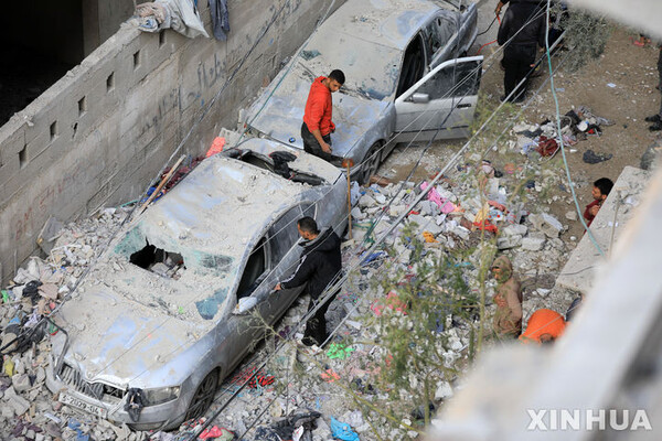 9일(현지시간) 가자지구 남부 도시 라파에서 이스라엘군의 공습으로 파손된 차량을 주민들이 살펴보고 있다. (출처: 뉴시스)