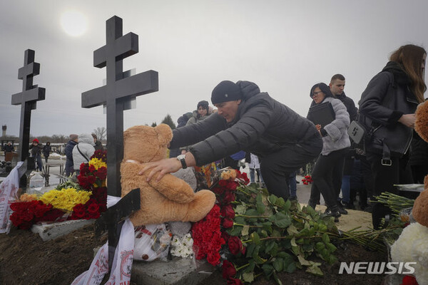 [하르키우=AP/뉴시스] 12일(현지시각) 우크라이나 하르키우에서 사람들이 러시아군의 공습으로 숨진 가족의 묘에 인형과 꽃을 놓고 있다. 우크라이나 당국은 지난 10일 러시아군의 주택가 공습으로 어린이 3명 포함 7명이 숨졌다고 밝혔다. 2024.02.13.