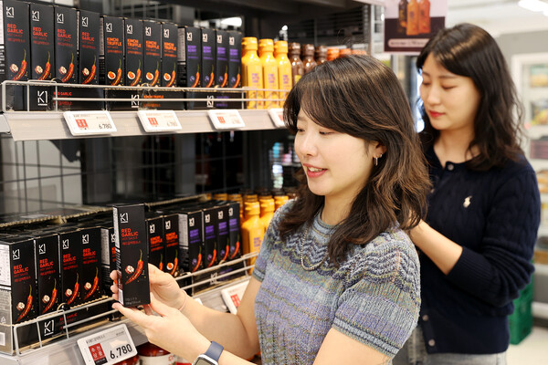교촌에프앤비 직원들이 이마트에 진열된 ‘K1 소스’ 상품을 살펴보고 있다. (제공: 교촌에프앤비)