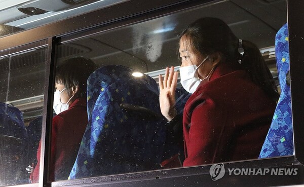 북한 여자축구 대표팀 선수가 25일 도쿄 하네다공항을 통해 일본에 입국한 뒤 버스에 올라 취재진을 향해 손을 흔들고 있다. (출처: 연합뉴스)