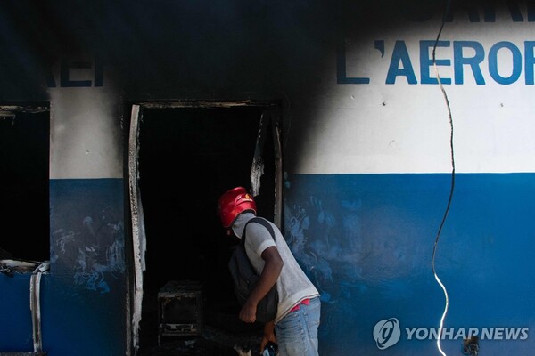 불에 탄 경찰서 안 살피는 아이티 주민. (출처:연합뉴스)