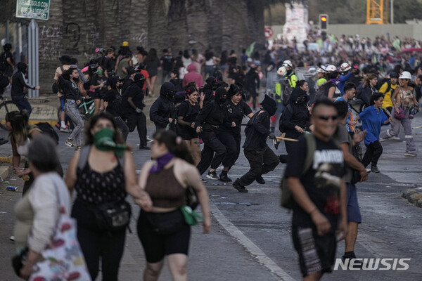 8일(현지시간) 세계 여성의 날을 맞아 칠레 산티아고에서 열린 성폭력 반대 시위에서 여성들이 경찰을 피해 도망치고 있다. (출처: 뉴시스)