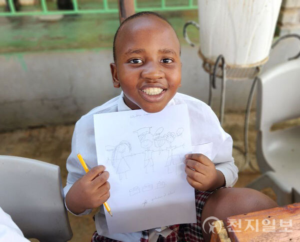 2022년 11월 22일 잠비아 베스트 버디즈 학교에서 열린 TGO 평화교육에서 한 학생이 자신을 그린 평화그림을 들고 미소짓고 있다. (제공: HWPL) ⓒ천지일보 2024.03.14.