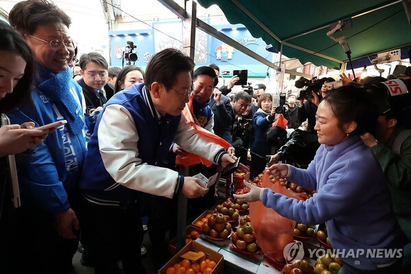 15일 오전 울산 남구 수암시장을 방문한 이재명 더불어민주당 대표가 시장에서 사과를 구매하고 있다. 2024.3.15 (출처: 연합뉴스)