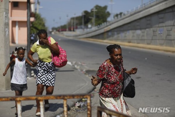6일(현지시각) 아이티 포르토프랭스에서 주민들이 경찰과 갱단의 충돌을 피해 달아나고 있다. (출처:AP/뉴시스)