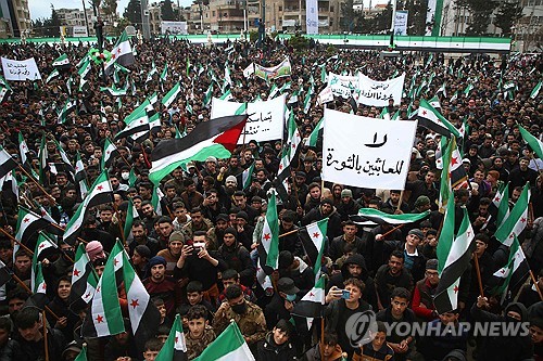 시리아인들이 15일(현지시간) 시리아 북서부 반군이 장악한 이들리브에서 민주화시위 13주년 기념 집회를 벌이고 있다. 2011년 3월 15일 반정부 시위가 일어난 이후 정부의 잔혹한 진압이 이어지며 내전이 촉발됐다. (출처: 연합뉴스)
