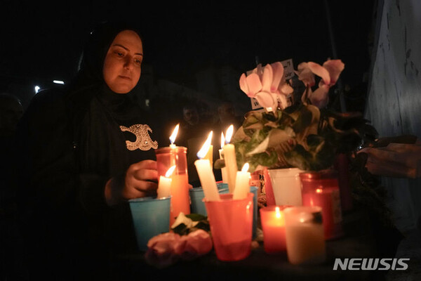 23일(현지시간) 한 레바논 여성이 모스크바 서쪽 가장자리에 있는 크로커스 시청에서 발생한 공격의 희생자들에 대한 연대를 보여주기 위해 레바논 베이루트의 러시아 대사관 밖에서 촛불을 밝히고 있다. (AP, 연합뉴스)