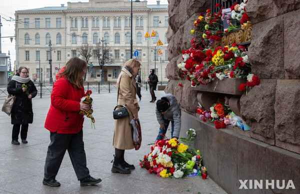 23일(현지시간) 러시아 상트페테르부르크에서 주민들이 모스크바 테러 희생자들을 추모하기 위해 꽃을 놓고 있다. (출처: 뉴시스)