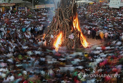 인도 아메다바드 외곽에서 힌두교 신자들이 홀리 축제 행사의 일부인 ‘홀리카 다한’ 의식을 치르기 위해 모닥불 주위를 걷고 있다. (출처: 연합뉴스)