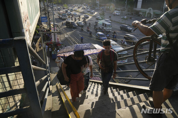 5일 필리핀 퀘존에서 무더위가 계속되는 가운데 한 여성이 우산을 이용해 햇볕을 피하고 있다. 필리핀의 일부 지역은 엘니뇨 현상으로 인해 열지수가 섭씨 45도에 이르는 등 극도로 더운 날씨가 이어지고 있다. (출처: 뉴시스)
