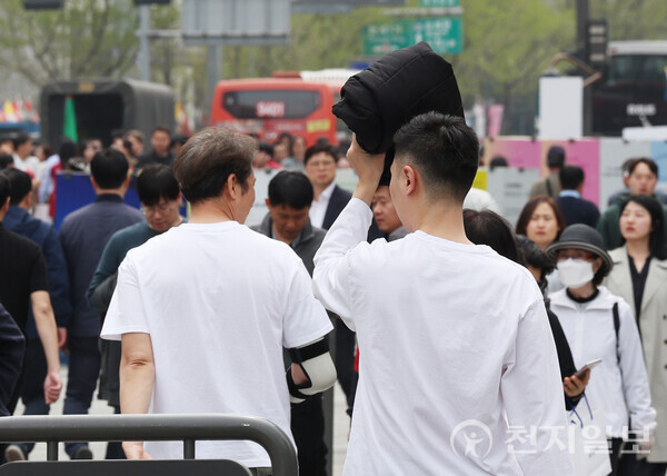 [천지일보=남승우 기자] 서울 낮 최고기온이 24도까지 오르며 포근한 날씨를 보인 8일 서울 종로구 광화문광장에서 시민이 외투로 햇빛을 가린 채 산책을 하고 있다. ⓒ천지일보 2024.04.08.