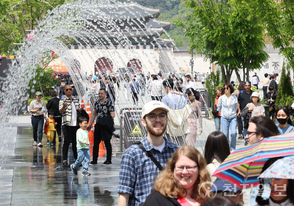 [천지일보=남승우 기자] 서울 지역 낮 기온이 25도까지 오르며 초여름 날씨를 보인 23일 서울 종로구 광화문광장에서 외국인 관광객들이 분수터널을 지나며 더위를 식히고 있다. ⓒ천지일보 2024.04.23.