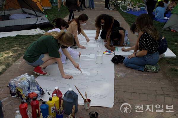 ⓒCheonji Ilbo 2024.04.30 Students paint a large poster with a "Boycott Now" message
