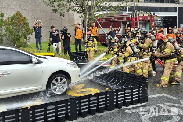 27일 오전 부산 부산진구의 한 아파트 지하 주차장에서 전기차 화재 상황을 가정한 소방 대응 합동 훈련이 진행되고 있다. 주차장 외부로 견인된 차량 주위로는 이동식침수조가 설치됐고, 부산소방은 호스를 이용해 물을 채우고 있다. 2024.08.27.(출처: 뉴시스)