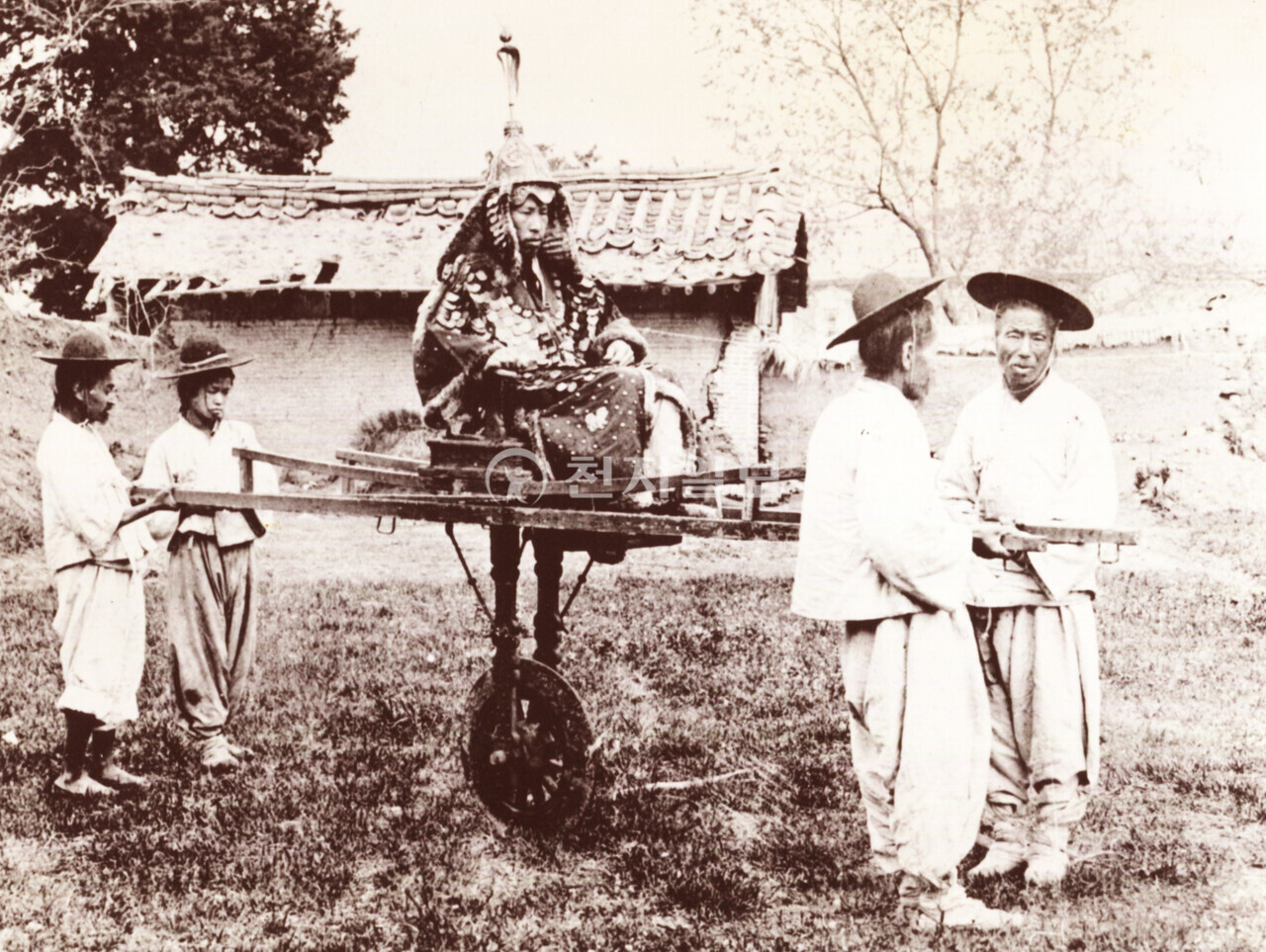 초헌을 탄 장군(1900년대). 초헌은 세종대왕 시기 만들어진 조선만의 독자적이고 나름 획기적인 것으로 종2품 이상의 벼슬아치가 타는 수레다. 종2품은 도지사나 광역단체장급의 벼슬이며, 무관은 정2품(군단장) 이상이 탈 수 있었다. 초헌은 무엇보다 채가 아주 길고 외바퀴가 밑으로 달려 있는 것이 특징이다. 또한 바퀴에는 쇠를 덧입혀 강도를 높였으며, 앉는 곳은 발을 올려놓을 수 있도록 제작됐다. 두 개의 긴 채를 각각 앞뒤에서 잡아끌고 밀게 되어 있으며, 보통 6~9명이 한 조를 이룬다. 사진 속 초헌은 4명이 끌고 밀게 돼 있다. (제공: 정성길 기록사진연구가) ⓒ천지일보 2024.09.16.