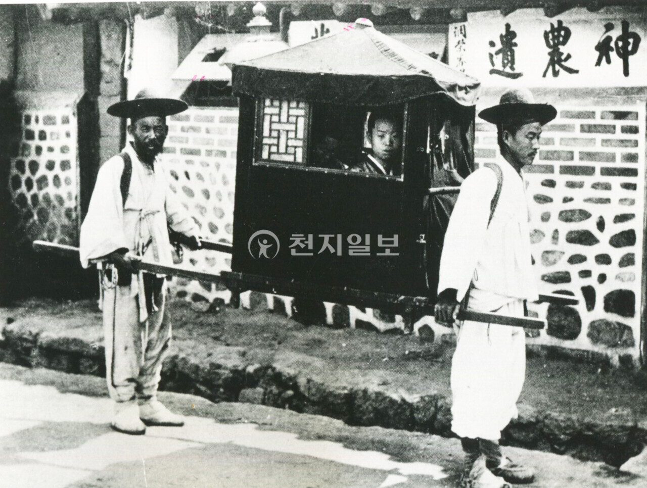 첫 신혼길 나들이(1900년대). 2인교 가마를 탄 새 신부의 모습이다. 뒤에 있는 가마꾼은 시야가 가려지기 때문에 예상치 못한 장애물로부터 발을 보호하기 위해 덧버선을 신발 위에 덧신었다. 가마는 앞쪽보다 뒤쪽의 끌채(가마채)가 더 길며 채를 잡는 위치도 앞 사람보다 길게 뒤로 잡는다. 이는 시야를 어느 정도 확보하기 위해서다. (제공: 정성길 기록사진연구가) ⓒ천지일보 2024.09.16.